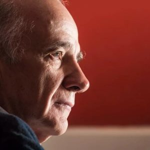 O economista André Lara Resende sob fundo vermelho