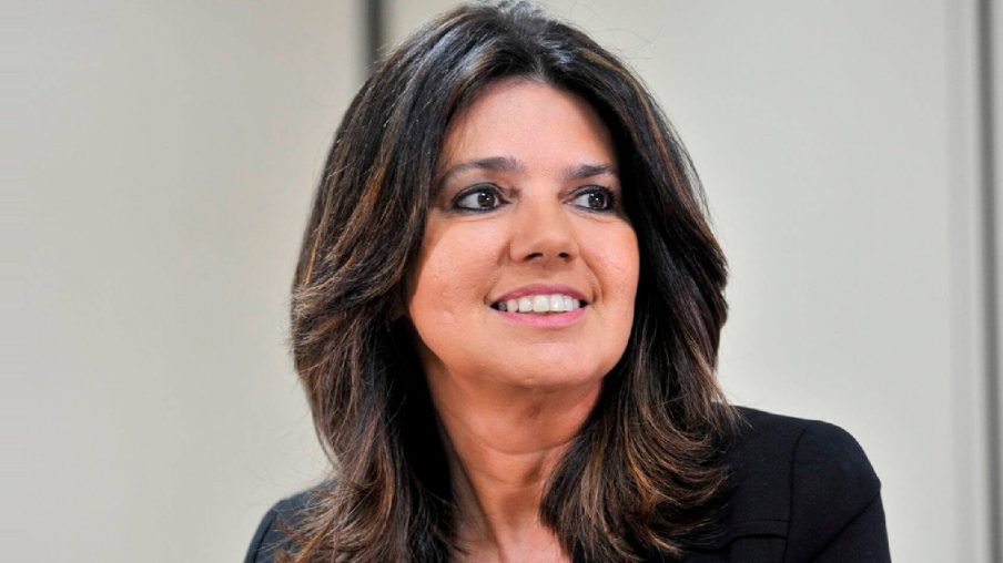 Foto de uma mulher branca com cabelos pretos e olhos escuros sorrindo.
