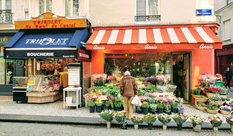 Açougue e floricultura em rua de Paris (Foto: Roxanne Boudrot/Unsplash)