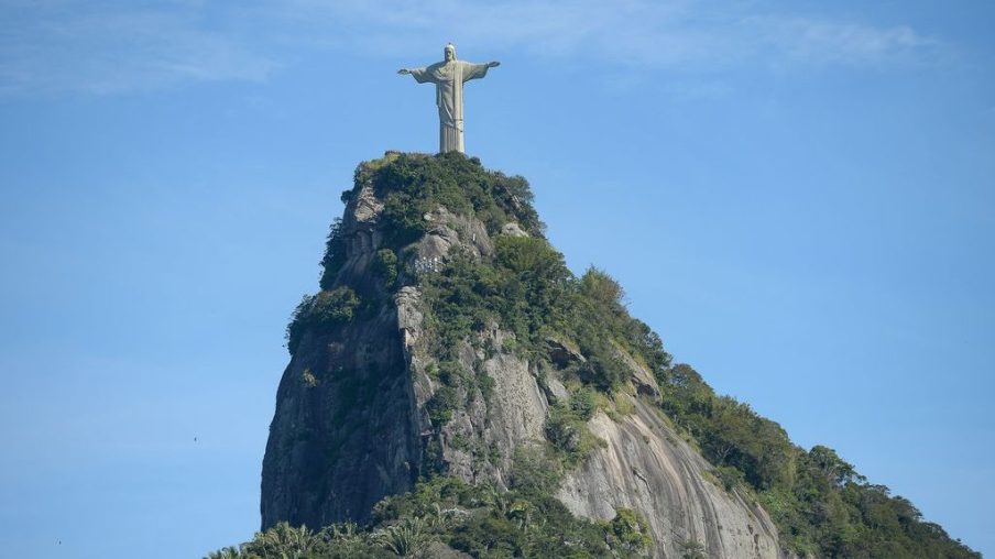 Foto do Cristo Redentor, um dos principais cartões postais do turismo no Brasil, tirada durante o dia.