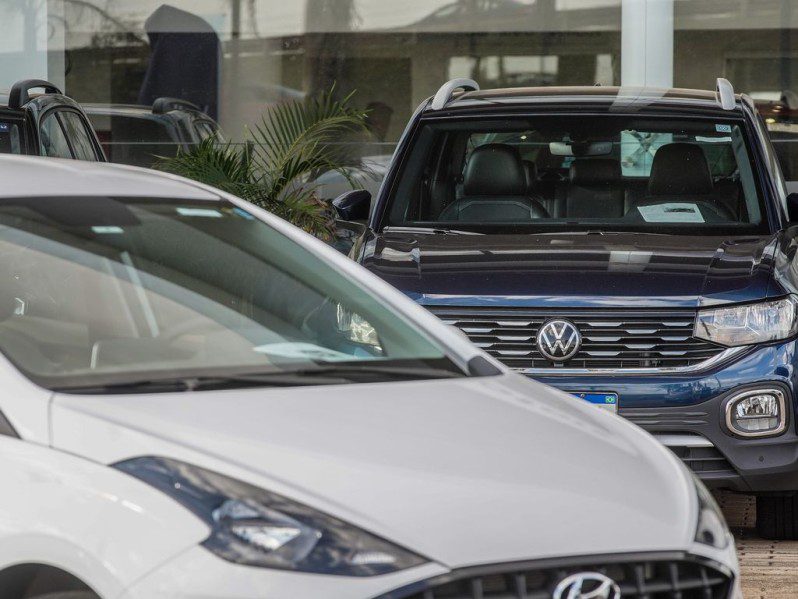 Foto de dois carros, um branco e um azul