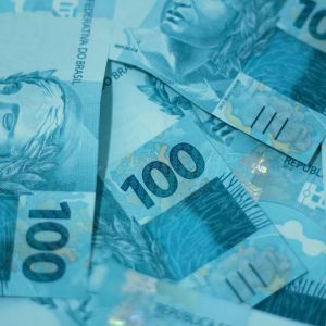 Imagem de várias notas de 100 reais para a matéria sobre quanto investir para ter uma renda mensal de R$ 3 mil