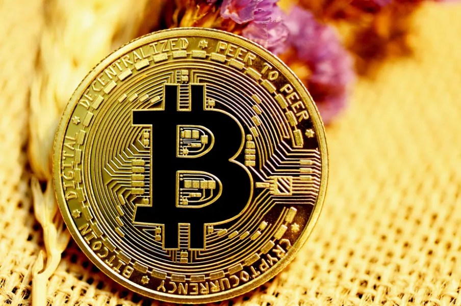 Foto de uma moeda de bitcoin dourada.