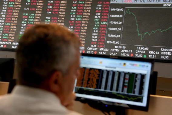Foto de um homem observado o painel do índice Ibovespa. A matéria traz a lista das 10 melhores pagadoras de dividendos da bolsa de valores.