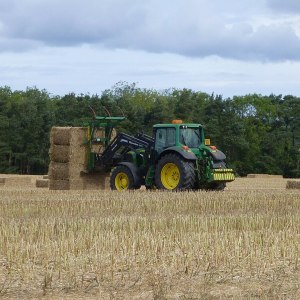 Imagem para matéria sobre investir no agronegócio em que aparece uma máquina agrícola em meio a uma plantação.