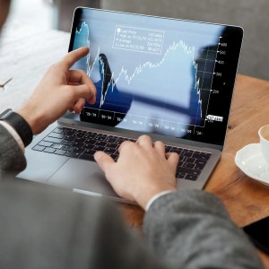Homem em computador operando na bolsa de valores
