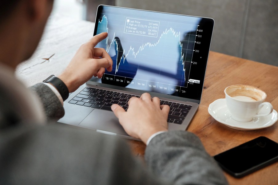 Homem em computador operando na bolsa de valores