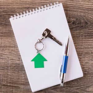 Bloco de papel com chave de imóvel e caneta