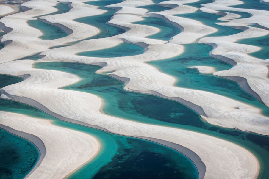 Imagem das dunas de areia dos Lencóis Maranhenses com lagos de cor verde.