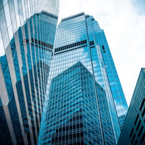 Foto de prédios de vidro com reflexo. A matéria explica quais a tendências do IFIX hoje e para 2025 e os melhores fundos imobiliários para investir