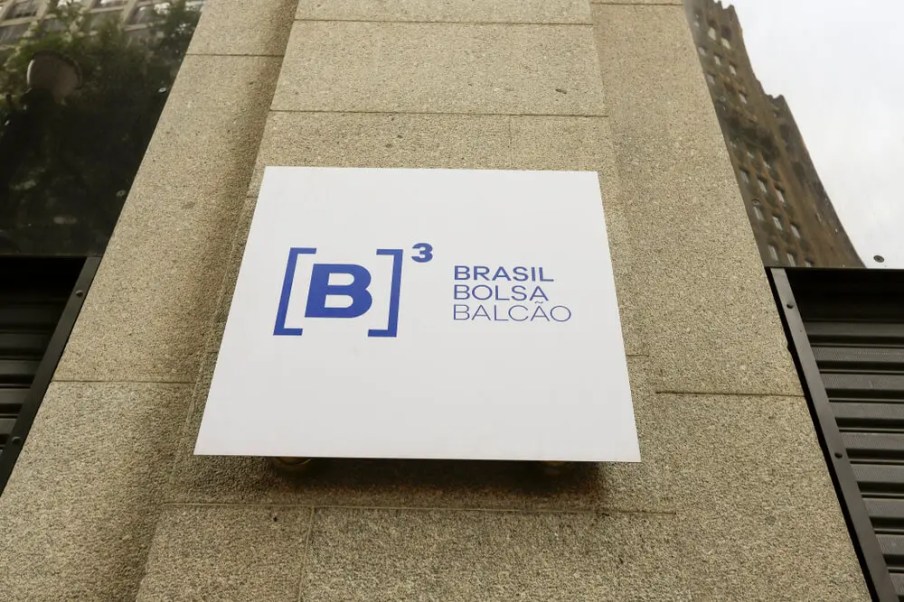 Foto do logo da B3 com os dizeres "Brasil, Bolsa e Balcão". A matéria explica novos horários de funcionamento da B3