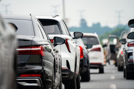 Imagem de vários carros parados em uma via que está com trânsito.