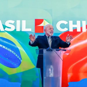 Foto do presidente do Brasil, Luiz Inácio Lula da Silva, em pódio durante visita à China, onde anunciou investimentos de empresas como GWM, Keeta e Mixue no Brasil